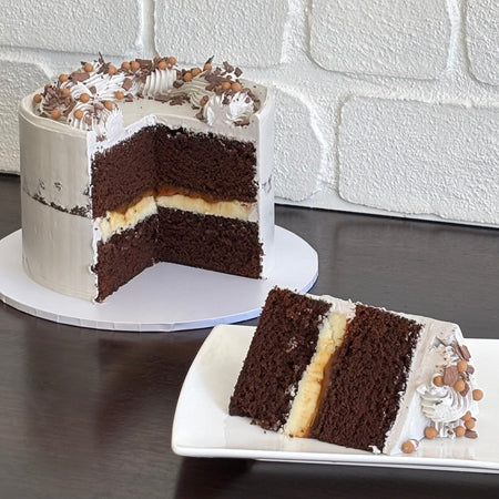 chocolate mud cake with white chocolate ganache and salted caramel sauce. Decorated with swiss meringue buttercream, caramel crispearls and chocolate shavings