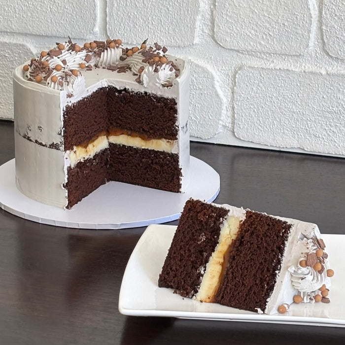chocolate mud cake with white chocolate ganache and salted caramel sauce. Decorated with swiss meringue buttercream, caramel crispearls and chocolate shavings