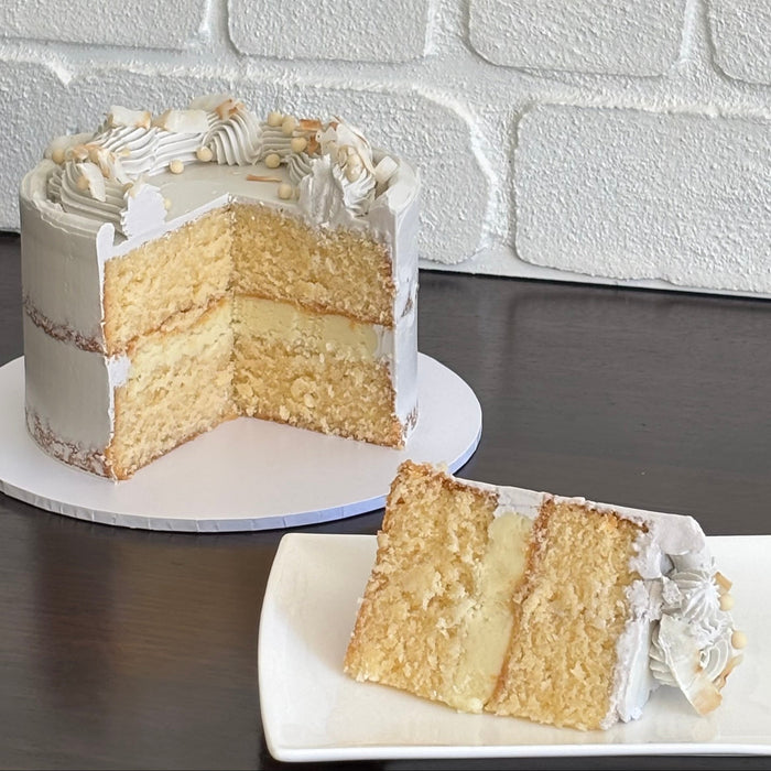 coconut mud cake layered with white chocolate ganache and finished with a semi named swiss meringue buttercream. Decorated with white crispearls and toasted coconut flakes