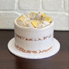 lemon mud cake layered with white chocolate ganache and lemon curd. Finished with a semi naked swiss meringue buttercream, white crisp pearls and fresh lemon pieces