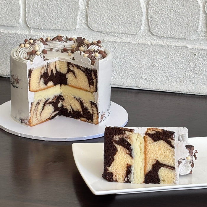 chocolate and white chocolate mud cake swirled together to create a marble mud cake, layered with white chocolate ganache. Finished with a semi naked swiss meringue buttercream, milk and white crispearls and chocolate shavings