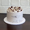 red velvet mud cake layered with cream cheese ganache, finished with a semi naked swiss meringue buttercream. Decorated with white crispearls and red velvet mud cake pieces 