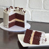 red velvet mud cake layered with cream cheese ganache, finished with a semi naked swiss meringue buttercream. Decorated with white crispearls and red velvet mud cake pieces 